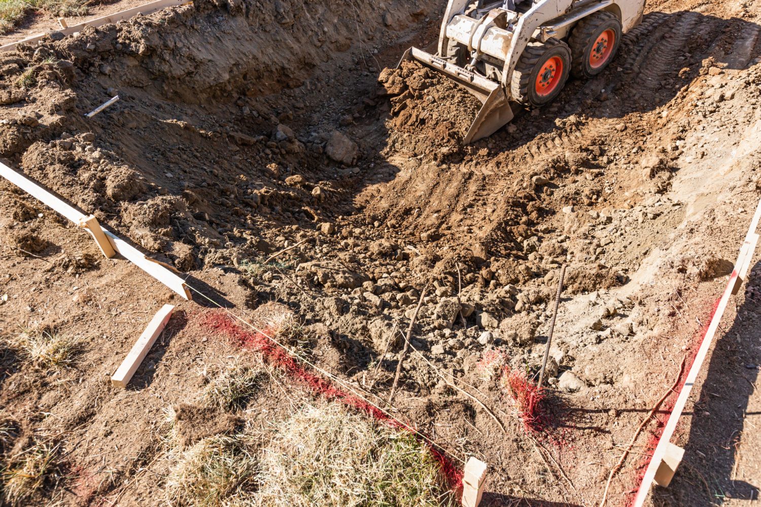 Small Bulldozer Digging In Yard For Pool Installation.